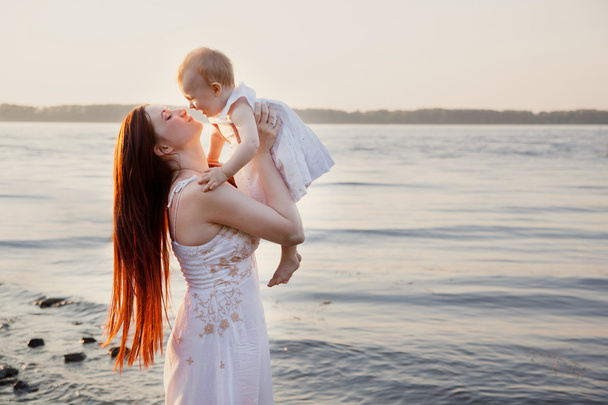 onnellinen äiti ja tytär hauskaa auringonlaskun rannalla
 - Valokuva, kuva