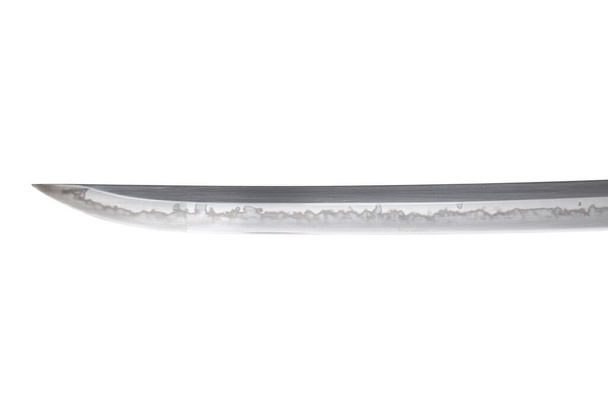 Japanese sword blade (made in China) on white background. Soft focus.  The wavy pattern on the blade edge is a line of hardness that a blacksmith makes so that the blade doesn't break. - Photo, Image