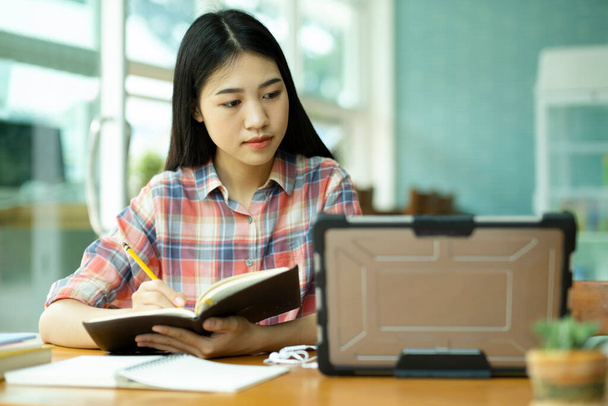 Молодая азиатская студентка учится на выезде. She using laptop and learning online. - Фото, изображение