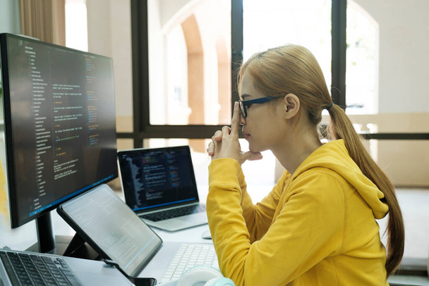 Young woman covering her face with the stress of work coding and programming software. frustrated on her work and out of control. - Foto, Imagen
