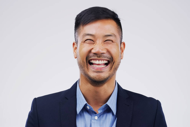 Theres no need for business to be serious. Studio portrait of a handsome young businessman laughing while standing against a grey background - Foto, Imagem