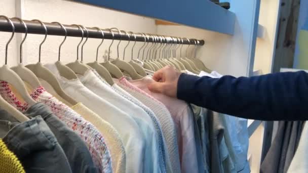 Consumer pulling clothing from hanger - Πλάνα, βίντεο