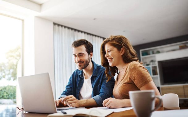 That looks like a great idea, we should try that too. a young couple watching online videos together while doing their monthly budget at home - Foto, Imagem