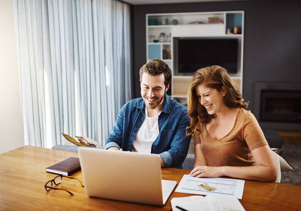 Teaming up to make the best financial choices. a young couple watching online videos together while doing their monthly budget at home - Fotografie, Obrázek