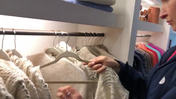 Woman placing clothing back to hanger - Materiał filmowy, wideo
