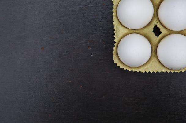 Fondo de huevos sobre una superficie de madera negra
 - Foto, Imagen