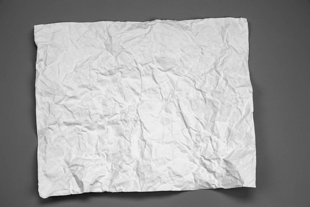white and gray crumpled paper on  gray background. crush paper so that it becomes creased and wrinkled. - Photo, Image
