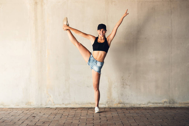 Shes beyond your stretch of imagination. an attractive young female street dancer practising out in the city - Zdjęcie, obraz