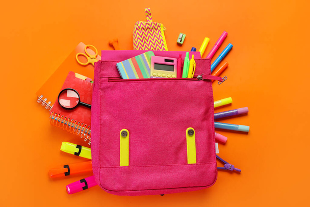 School backpack with stationery on red background - Photo, Image