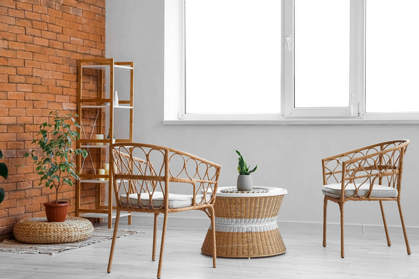 Interior of cozy living room with rattan table, armchairs and shelving unit - Valokuva, kuva