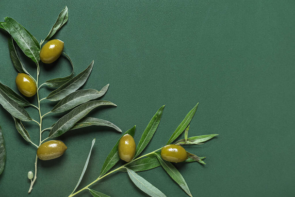 Green olives with leaves on color background - 写真・画像
