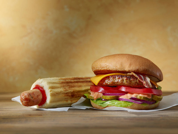 fresh tasty burger and hotdog on wooden table - Photo, Image