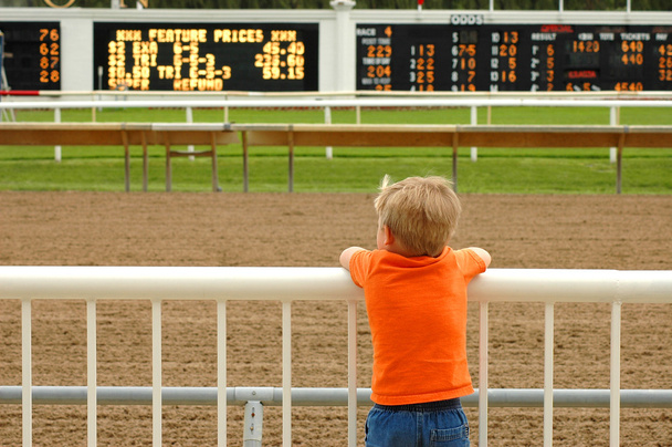 młody chłopak czeka na konie w wyścigu śledzić - Zdjęcie, obraz
