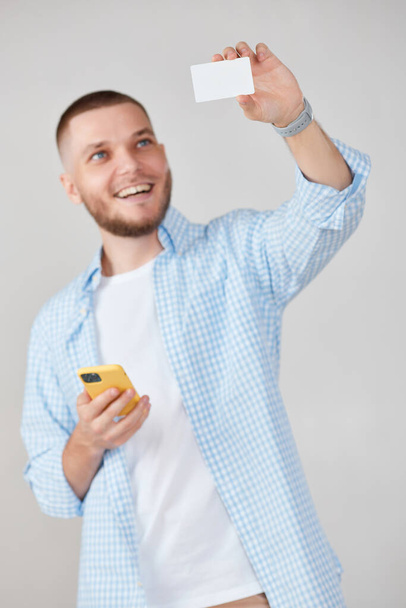 handsome man with mobile cell phone and credit bank card shopping online - Foto, imagen