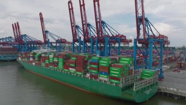 Majestic cargo ship with loaded thousands of overseas containers. Ascending footage of cargo terminal in harbour. Intermodal transport and global logistics. Hamburg, Germany. - Video, Çekim