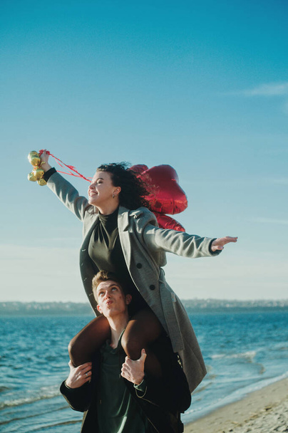 Couple joyeux avec un coeur rouge ballons sur la plage - Photo, image