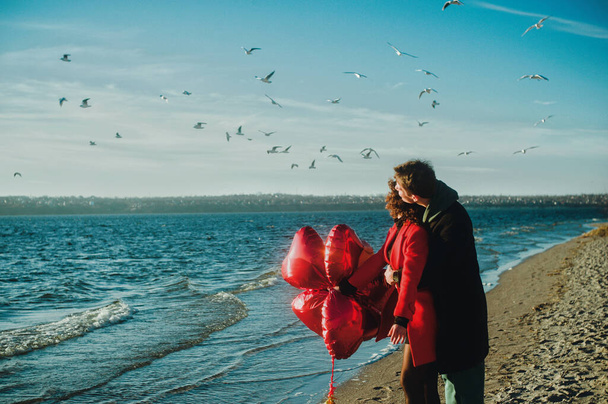 Šťastný běžecký pár s červeným srdcem balónky na pláži - Fotografie, Obrázek