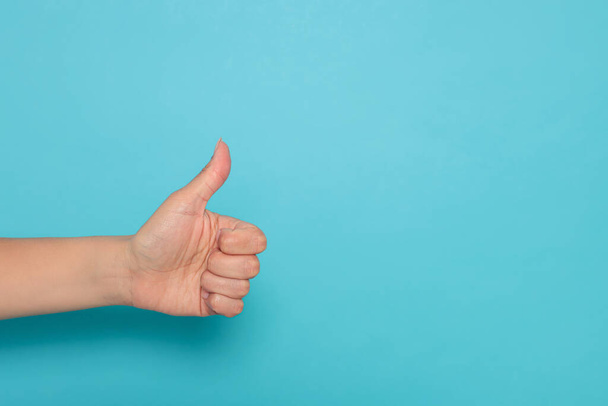 Woman showing thumb up on light blue background, closeup. Space for text - Foto, imagen