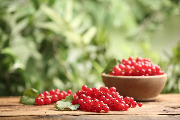 Ripe red currants on wooden table against blurred background. Space for text - Foto, imagen