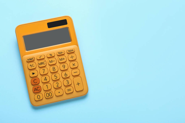 Orange calculator on turquoise background, top view. Space for text - Fotó, kép