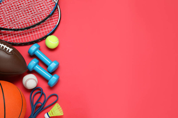 Set of different sports equipment on red background, flat lay. Space for text - Zdjęcie, obraz