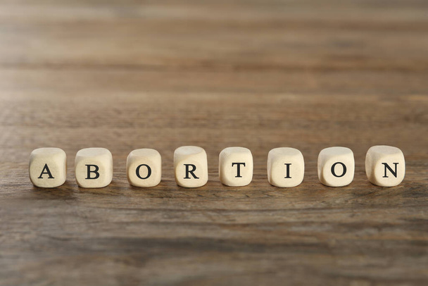 Word Abortion made of cubes on wooden table, closeup - Foto, Imagem