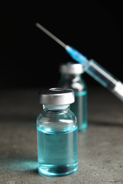 Vials and syringe on grey table. Vaccination and immunization - Fotografie, Obrázek