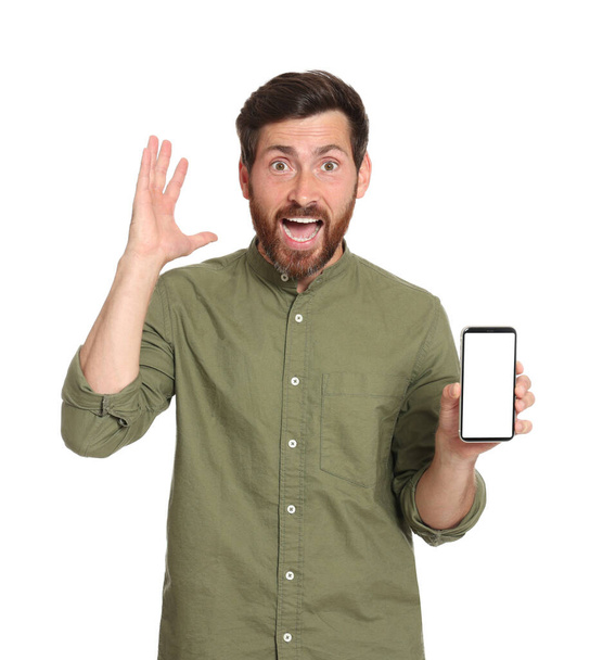 Emotional man with phone on white background - Φωτογραφία, εικόνα