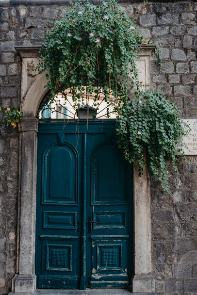 Ancient wooden door in old stone castle wall. Front Door and exterior of a beautiful old building on a street in an Europe town. - Fotografie, Obrázek