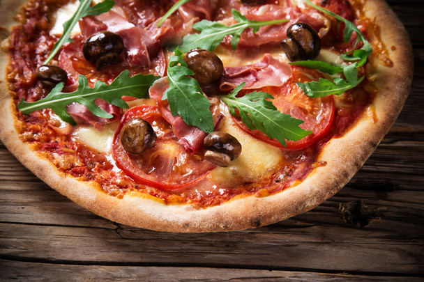 Delicious italian pizza served on wooden table - Foto, imagen