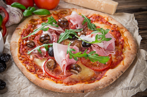 Deliciosa pizza italiana servida sobre mesa de madera
 - Foto, Imagen