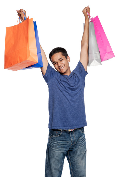 ショッピング バッグで幸せな若い男 - 写真・画像