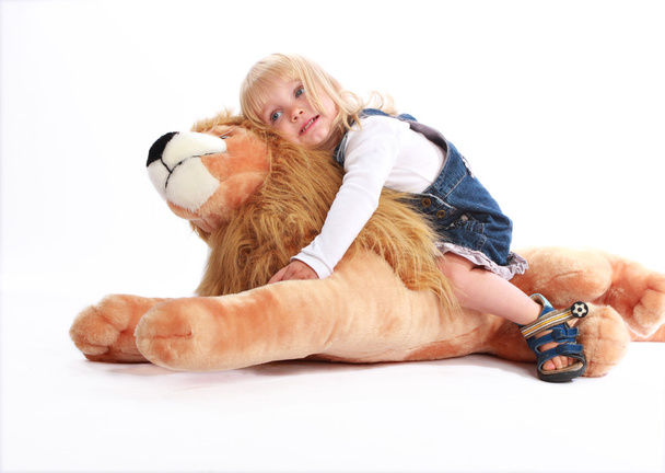 Tyttö nojaa lelu leijona
 - Valokuva, kuva