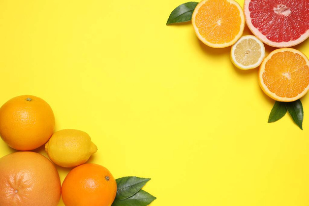 Different citrus fruits on yellow background, flat lay. Space for text - Valokuva, kuva