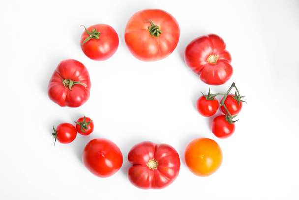 Frame of different ripe tomatoes on white background, flat lay. Space for text - Fotó, kép