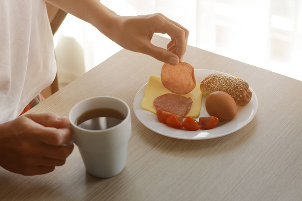 Женщина с вкусным питательным завтраком за деревянным столом в помещении, крупным планом. Доброе утро. - Фото, изображение