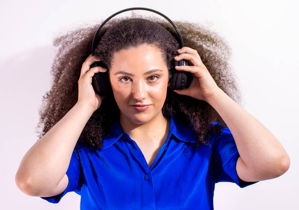 Νεαρό αφρο-μαλλιά κορίτσι ακούγοντας μουσική με ακουστικά και να αντιγράψετε χώρο - Φωτογραφία, εικόνα