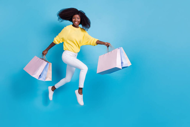 Full size body side profile photo of young girl running retail shopping buyer isolated on blue color background. - 写真・画像