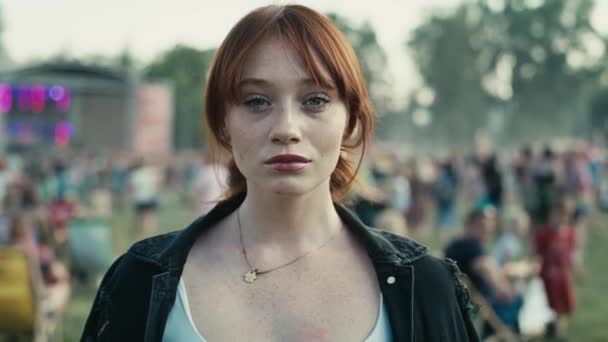 Portrait of ginger haired young caucasian woman at music festival showing neutral emotions. Shot with RED helium camera in 8K.  - Materiał filmowy, wideo