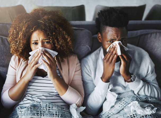 Portrait of a sick couple suffering from the flu, corona or sinus at home together, feeling unwell and weak. Girlfriend and boyfriend in quarantine, recovering from a virus and resting indoors. - Fotoğraf, Görsel