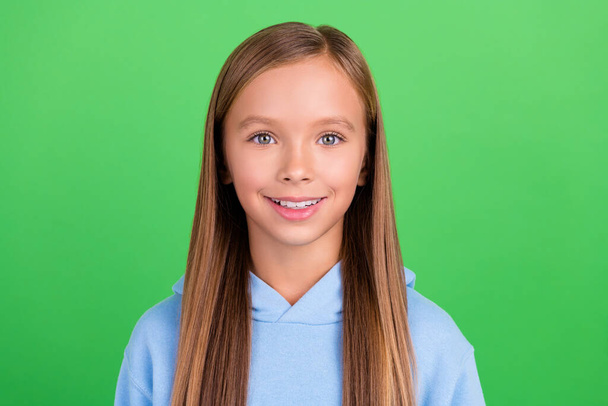 Close up photo of cheery little schoolgirl model toothy beaming smile dressed stylish blue sport look isolated on green color background. - Fotoğraf, Görsel