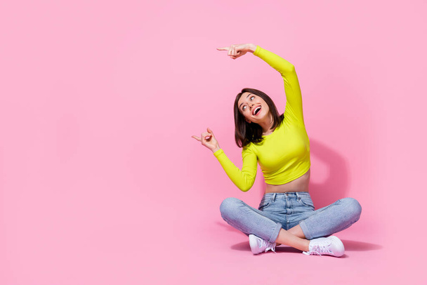 Photo of nice girlfriend lady wear green lime color outfit sit arm index promo empty space leg crossed isolated on pink color background. - Foto, immagini