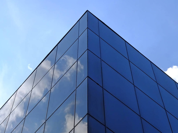 Modern glass building against the blue sky. Bottom view of modern skyscraper in business district - Φωτογραφία, εικόνα