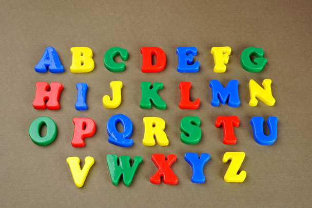 Colorful English alphabet on brown background - Φωτογραφία, εικόνα