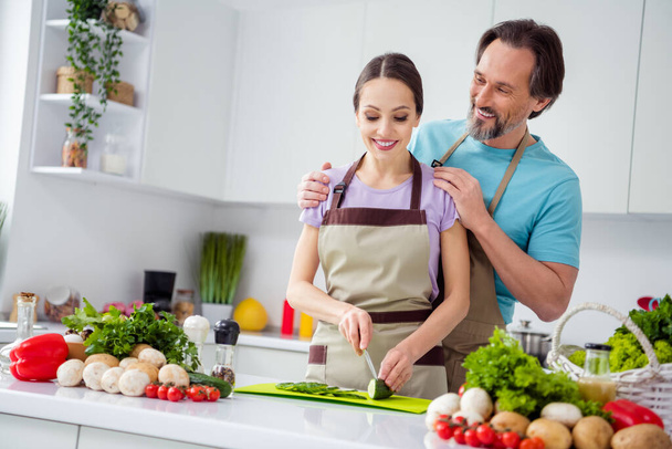Portrait of two idyllic positive people embrace chopping fresh healthy vegetables kitchen indoors. - Foto, Imagen