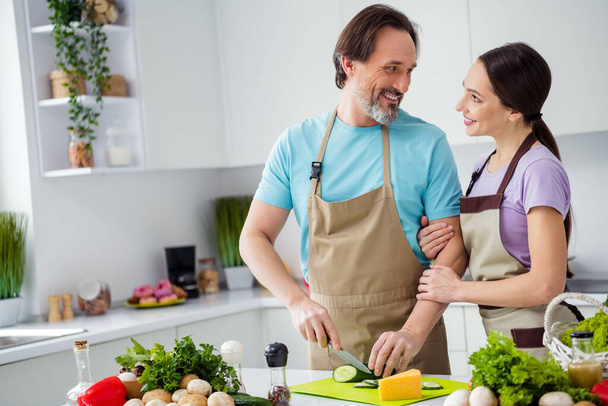 Portrait of two idyllic lovely partners embrace chop fresh organic vegetables enjoy cooking kitchen indoors. - Photo, Image