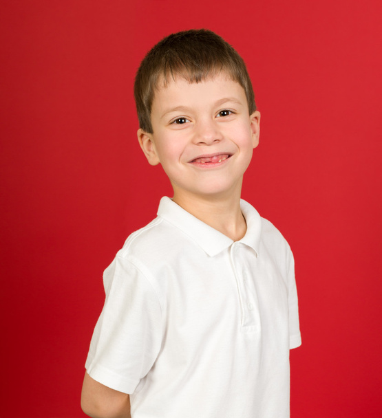 Grijnzende jongen portret op rood - Foto, afbeelding