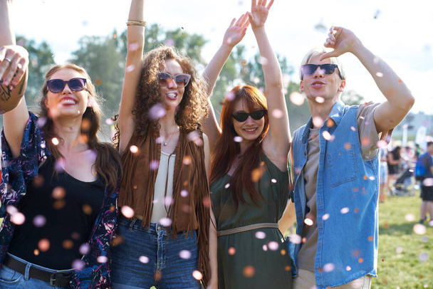 Group of young caucasian friends dancing and having fun on music festival among confetti  - Foto, imagen
