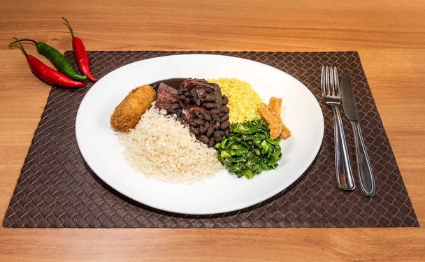 Delicious feijoada plate. Brazilian typical cuisine made with black beans and pork. - Foto, Imagem