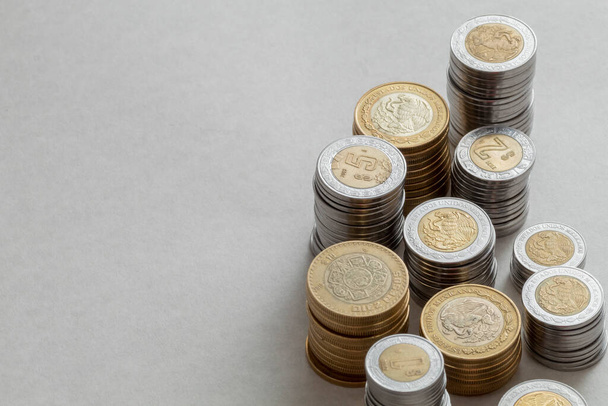 Mexican peso coins of different denominations stacked on a table with copy space. - Foto, Bild